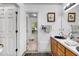 Bright bathroom boasts a wooden vanity and a view into an adjacent room at 105 Hobson Pl, Louisburg, NC 27549