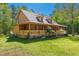 Two-story home featuring a welcoming porch, dormer windows, and a well-manicured lawn, surrounded by greenery at 105 Hobson Pl, Louisburg, NC 27549