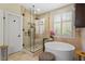 Bright bathroom featuring a glass enclosed shower, a soaking tub, neutral stone and ample natural light at 11 Swallow Tail Ct, Pittsboro, NC 27312