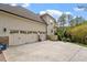 Three car garage and neutral colored siding, with large driveway, and landscaped garden at 11 Swallow Tail Ct, Pittsboro, NC 27312