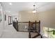 Hallway featuring a staircase with wood and iron banisters and an overview of a sunroom at 11 Swallow Tail Ct, Pittsboro, NC 27312
