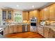Charming kitchen featuring custom wood cabinetry, stainless appliances, granite countertops and hardwood floors at 11 Swallow Tail Ct, Pittsboro, NC 27312