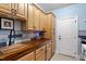 Charming laundry room featuring custom wood countertops, blue backsplash, and a utility sink at 11 Swallow Tail Ct, Pittsboro, NC 27312