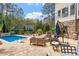 Inviting outdoor patio with comfortable seating, lush landscaping, and a heated pool at 11 Swallow Tail Ct, Pittsboro, NC 27312