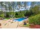Beautiful backyard with a sparkling pool, lounge chairs, and lush landscaping at 11 Swallow Tail Ct, Pittsboro, NC 27312