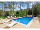 Relaxing backyard features a sparkling pool, lounge chairs, and mature trees at 11 Swallow Tail Ct, Pittsboro, NC 27312