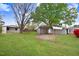 Spacious backyard with mature trees, storage buildings, and a metal carport at 1149 Us-701 Hwy, Four Oaks, NC 27524