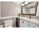 Bathroom vanity with granite counters, decorative mirror, and tile backsplash at 1149 Us-701 Hwy, Four Oaks, NC 27524
