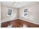 Bright bedroom with hardwood floors, ceiling fan, and large windows with exterior views at 1149 Us-701 Hwy, Four Oaks, NC 27524