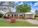 Charming single-story home with a carport, brick accents, and vibrant landscaping at 1149 Us-701 Hwy, Four Oaks, NC 27524