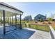 Relaxing covered back deck with gray wood, overlooking the manicured lawn and backyard at 1165 Saint Cloud Loop, Apex, NC 27523