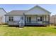 Back of the home featuring a covered porch, wood deck and well-maintained yard at 1165 Saint Cloud Loop, Apex, NC 27523