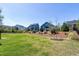 Large backyard with lush grass, mulched areas, and view of neighboring houses at 1165 Saint Cloud Loop, Apex, NC 27523