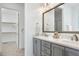 Bathroom features a double vanity with gray cabinets, quartz countertop, and access to a large closet at 1165 Saint Cloud Loop, Apex, NC 27523