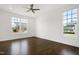 Bedroom features hardwood floors, ceiling fan, and natural light from large windows overlooking backyard at 1165 Saint Cloud Loop, Apex, NC 27523