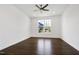 Well lit bedroom featuring hard wood floors, ceiling fan, and a window overlooking landscaped yard at 1165 Saint Cloud Loop, Apex, NC 27523