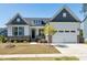 Charming home with a two-car garage, stone accents, manicured lawn, and beautiful landscaping at 1165 Saint Cloud Loop, Apex, NC 27523