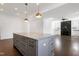 Open-concept living room featuring a large kitchen island and a cozy fireplace at 1165 Saint Cloud Loop, Apex, NC 27523