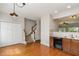 Traditional kitchen with hardwood floors, wood cabinetry, staircase, and view into living room at 117 Gallent Hedge Trl, Apex, NC 27539