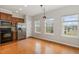 Traditional kitchen with hardwood floors, stainless steel refrigerator, and three large windows at 117 Gallent Hedge Trl, Apex, NC 27539