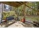 A covered patio with a bench, various potted plants, and view of trees at 117 Gallent Hedge Trl, Apex, NC 27539