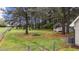 Spacious fenced backyard with mature trees, a fire pit, and ample space for outdoor activities at 120 Stillmeadow Dr, Louisburg, NC 27549