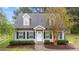 Charming home featuring neutral siding, black shutters, dormer windows, and well-maintained landscaping at 120 Stillmeadow Dr, Louisburg, NC 27549