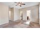 Bedroom with neutral carpet and ceiling fan near two bathrooms, closet, and several windows at 13 Parkers Pointe Dr, Benson, NC 27504