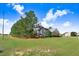 Charming single-story home featuring a well-maintained lawn, mature trees, and inviting curb appeal under a sunny sky at 13 Parkers Pointe Dr, Benson, NC 27504