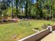 Spacious backyard features a play structure and a slide, framed by beautiful landscaping and mature trees at 1307 Crabapple Ln, Raleigh, NC 27607