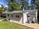 Charming home's backyard featuring a well-maintained lawn, gravel area, and exterior in a wooded setting at 1307 Crabapple Ln, Raleigh, NC 27607