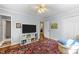 Light, airy bedroom with a large rug, ceiling fan, storage with toys, and a view of the en suite bathroom at 1307 Crabapple Ln, Raleigh, NC 27607