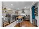 Sleek kitchen equipped with stainless steel appliances, open shelving, and hardwood floors at 1307 Crabapple Ln, Raleigh, NC 27607