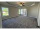 Expansive main bedroom featuring plush carpet, a tray ceiling, and large windows at 14 Cricket Hill Way, Benson, NC 27504