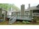 Back of the house with multi-level deck, multiple chimneys, and landscaped backyard at 1415 Quarter Pt, Raleigh, NC 27615