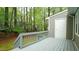 Backyard featuring large deck, door to storage, and lush trees at 1415 Quarter Pt, Raleigh, NC 27615