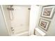 Clean white bathroom featuring a shower-tub with white curtain, framed art pieces, and toilet at 1415 Quarter Pt, Raleigh, NC 27615