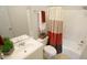 Well lit bathroom featuring a shower-tub with decorative curtain, white sink and toilet at 1415 Quarter Pt, Raleigh, NC 27615