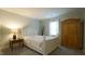 Cozy bedroom featuring a queen bed, side table with lamp, carpet flooring, and bright natural light at 1415 Quarter Pt, Raleigh, NC 27615