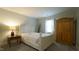 Inviting bedroom with soft carpet, white bed, side table, wooden wardrobe and bright natural light at 1415 Quarter Pt, Raleigh, NC 27615
