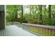Spacious gray deck area surrounded by lush greenery and mature trees creates a private outdoor living space at 1415 Quarter Pt, Raleigh, NC 27615