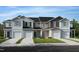 Charming townhomes showcasing varied siding colors and attached garages against a bright blue sky at 152 Parker Ln, Mebane, NC 27302