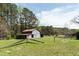Rustic barn with a rusty metal roof surrounded by green fields and trees on a sunny day at 1556 Pleasants Rd, Wendell, NC 27591