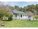 Exterior view of a cozy home featuring a green roof, front porch, and a well-maintained yard at 1556 Pleasants Rd, Wendell, NC 27591