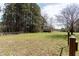 Expansive grassy land with mature trees, fencing, and distant shed, perfect for outdoor activities at 1556 Pleasants Rd, Wendell, NC 27591