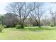 Picturesque open land with large trees and a distant tent, creating a serene and natural setting at 1556 Pleasants Rd, Wendell, NC 27591