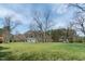 Large grassy yard with mature trees and a charming house, perfect for outdoor living and relaxation at 1556 Pleasants Rd, Wendell, NC 27591