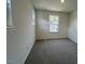 Empty bedroom features neutral carpet, white walls, and a window with a view of the outdoors at 158 Parker Ln, Mebane, NC 27302