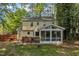 Backyard view showcasing a wooden deck, fully screened sunroom, and lush greenery at 1600 S Wade Ave, Garner, NC 27529