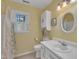 Bathroom features a white vanity, cabinet, toilet, shower with curtain, and a window for natural light at 1600 S Wade Ave, Garner, NC 27529